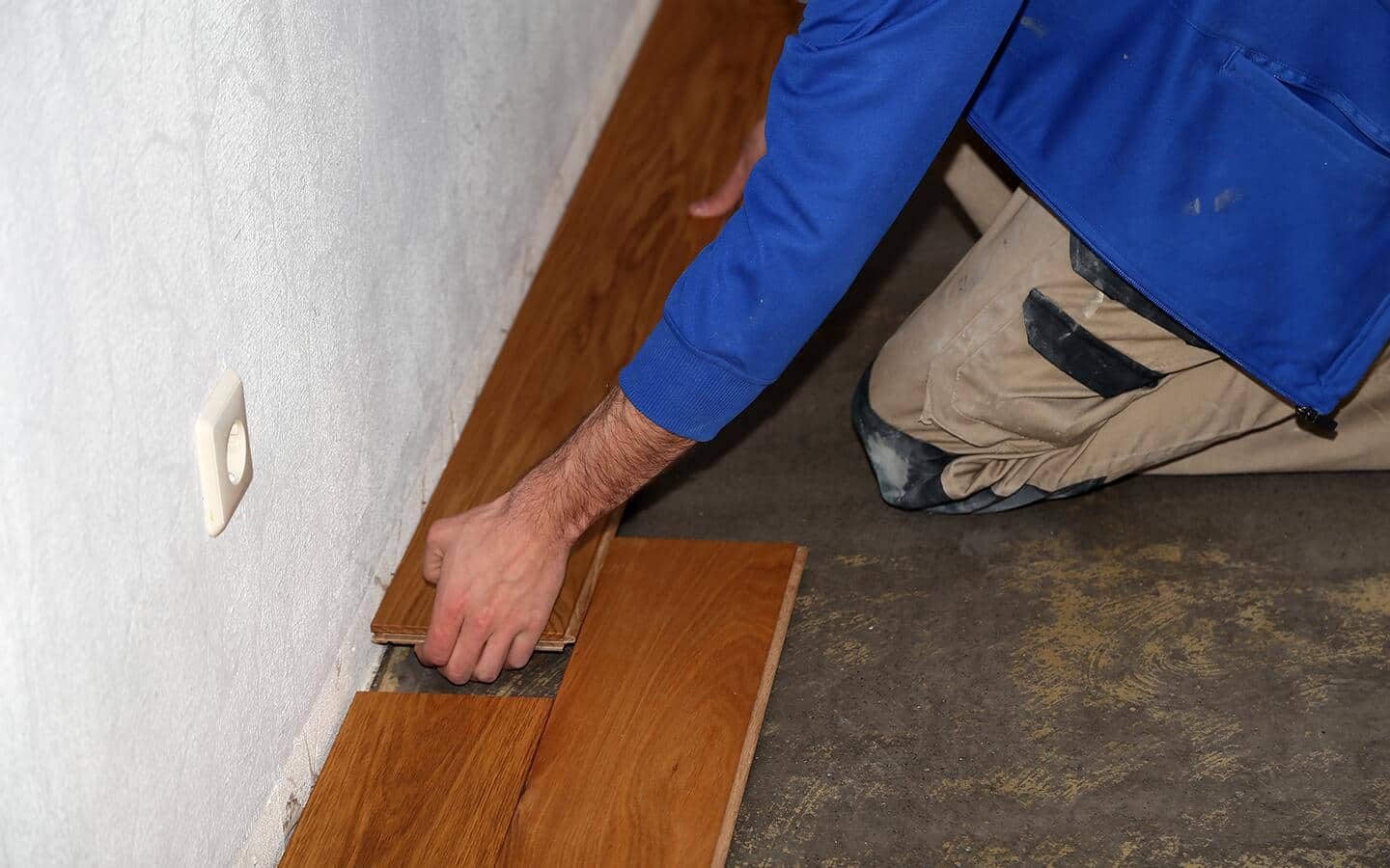 A person removing vinyl flooring from a concrete floor. A person removing vinyl flooring from a concrete floor.