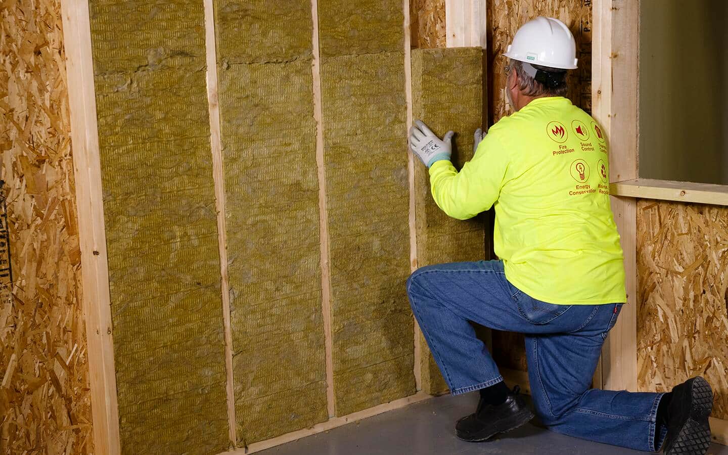 A person installs wall insulation. A person installs wall insulation.