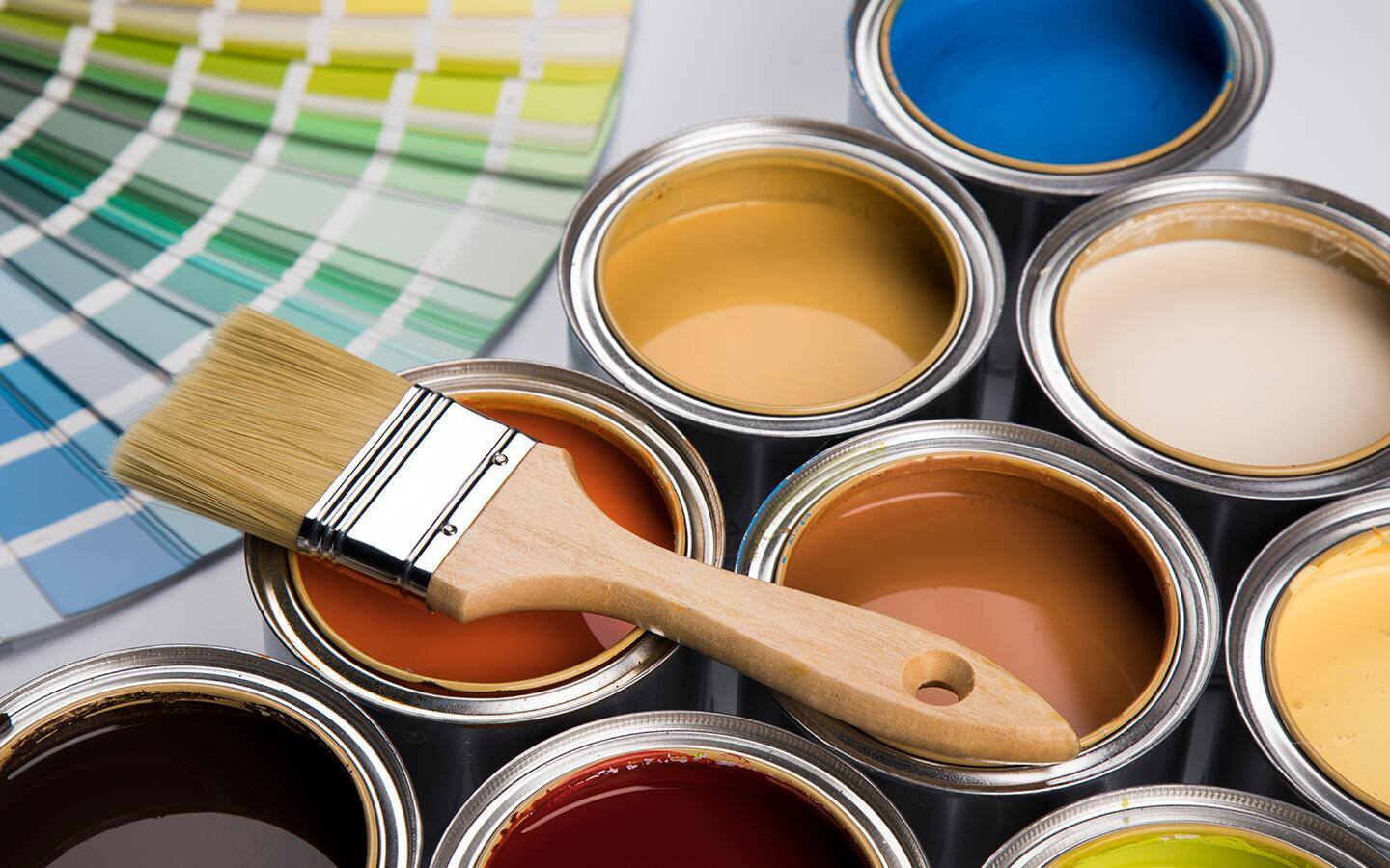 Paint cans and color samples displayed on a table. Paint cans and color samples displayed on a table.