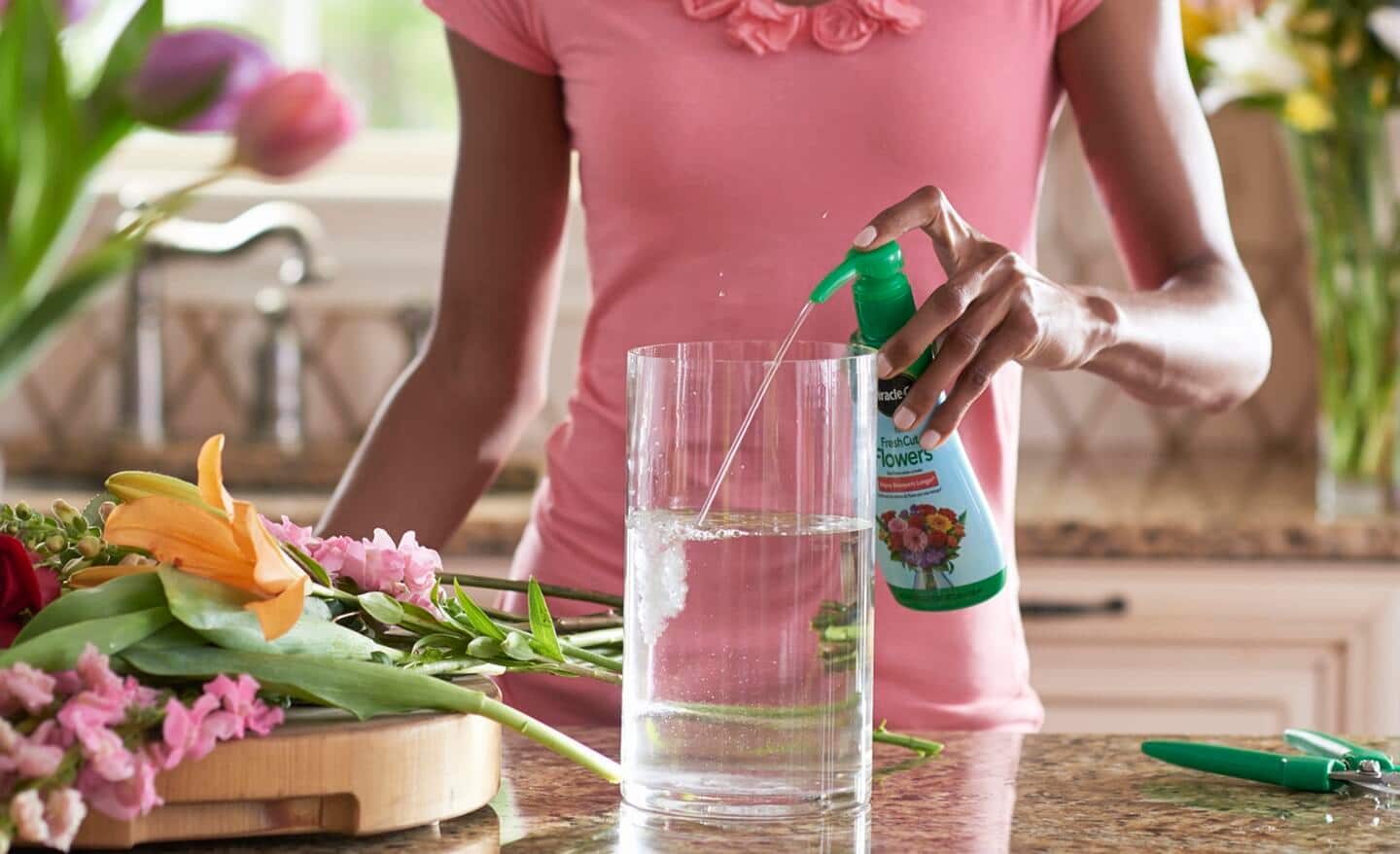 Gardener adds floral food to water in vase