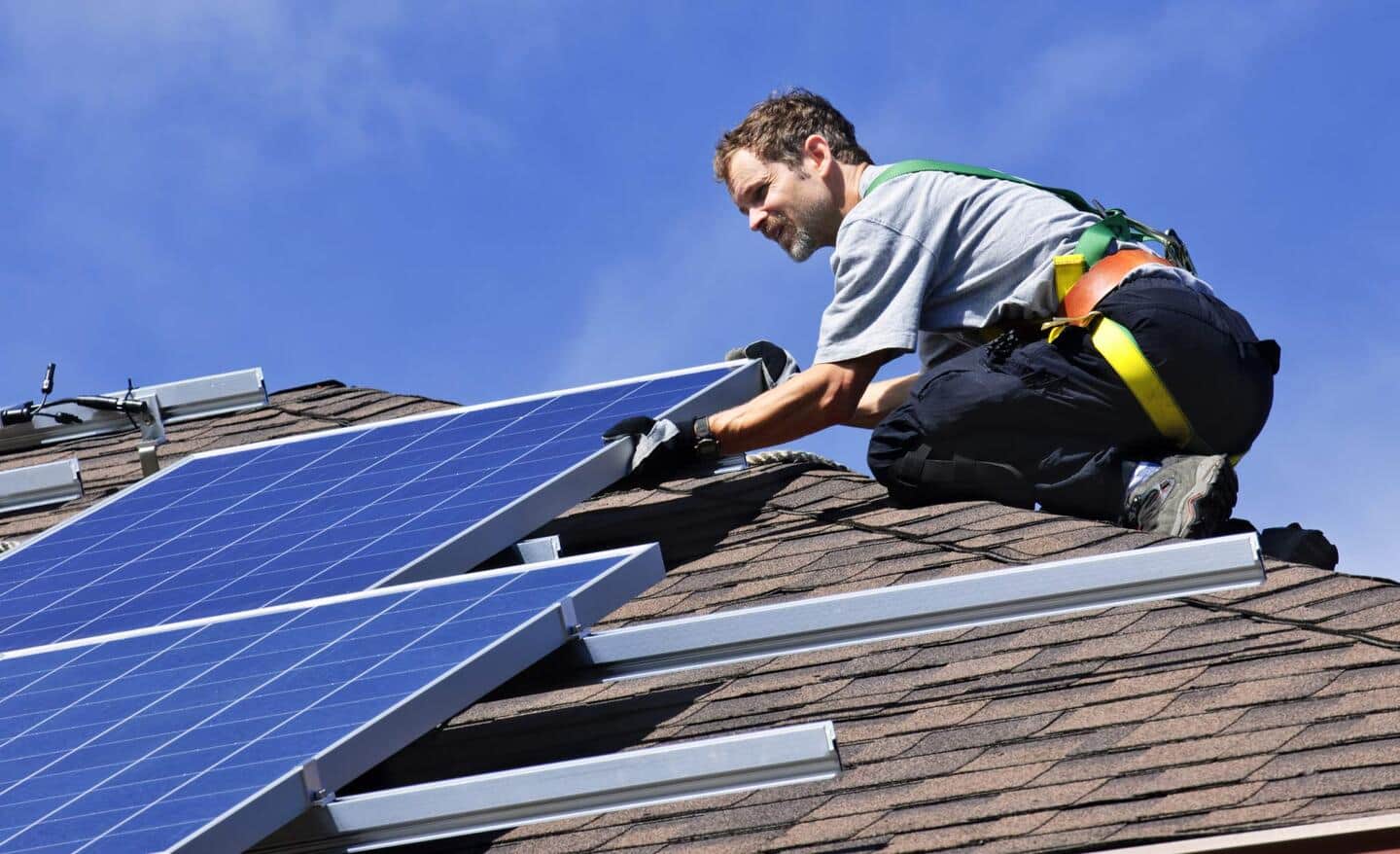 A Pro installs solar panels on a roof.