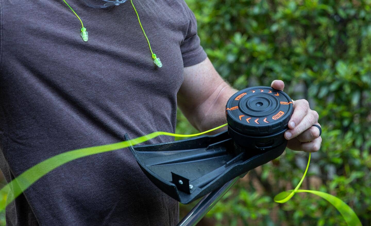 A person refills a string trimmer with fresh trimmer line.
