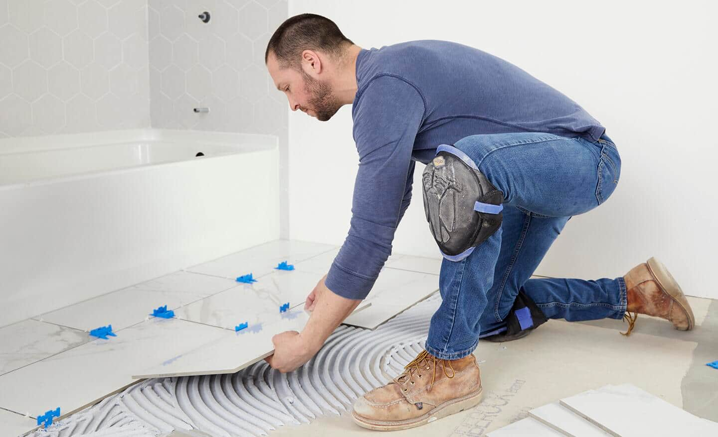 Tile being installed in front of a bathtub.