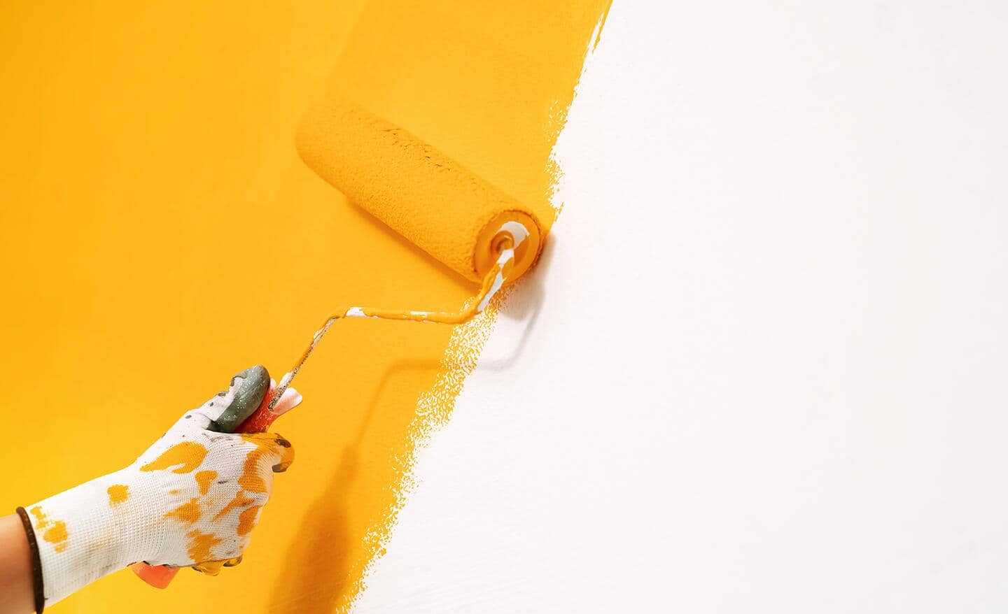 A person rolling paint onto a wall.