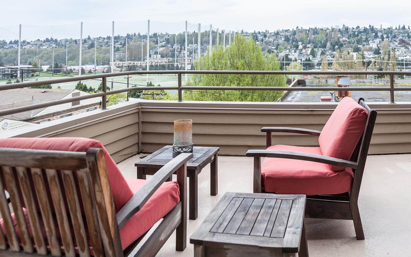 Red armchairs sit on a rooftop deck. Red armchairs sit on a rooftop deck.