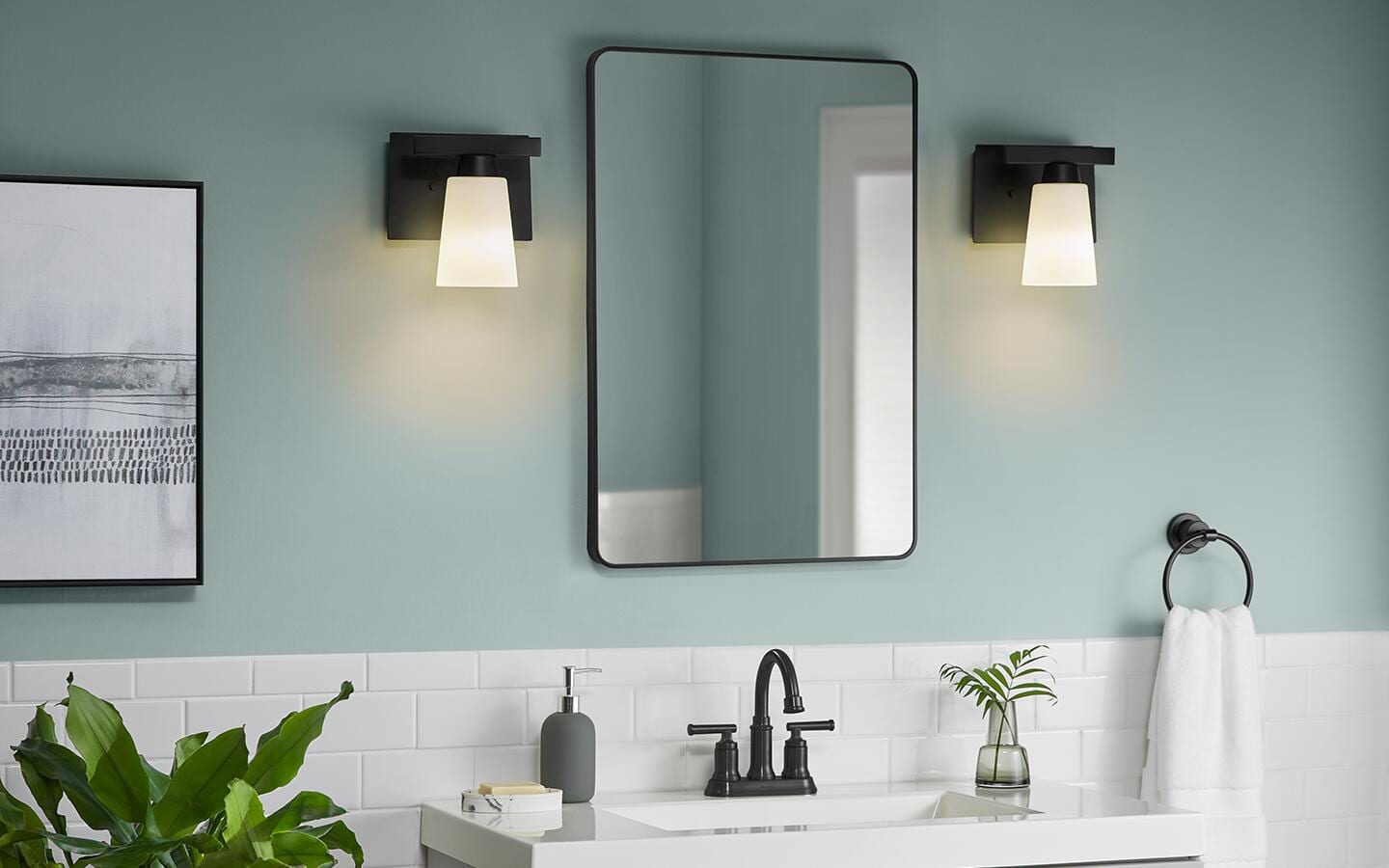 White, frosted-glass vanity lights placed on either side of a bathroom mirror. White, frosted-glass vanity lights placed on either side of a bathroom mirror.
