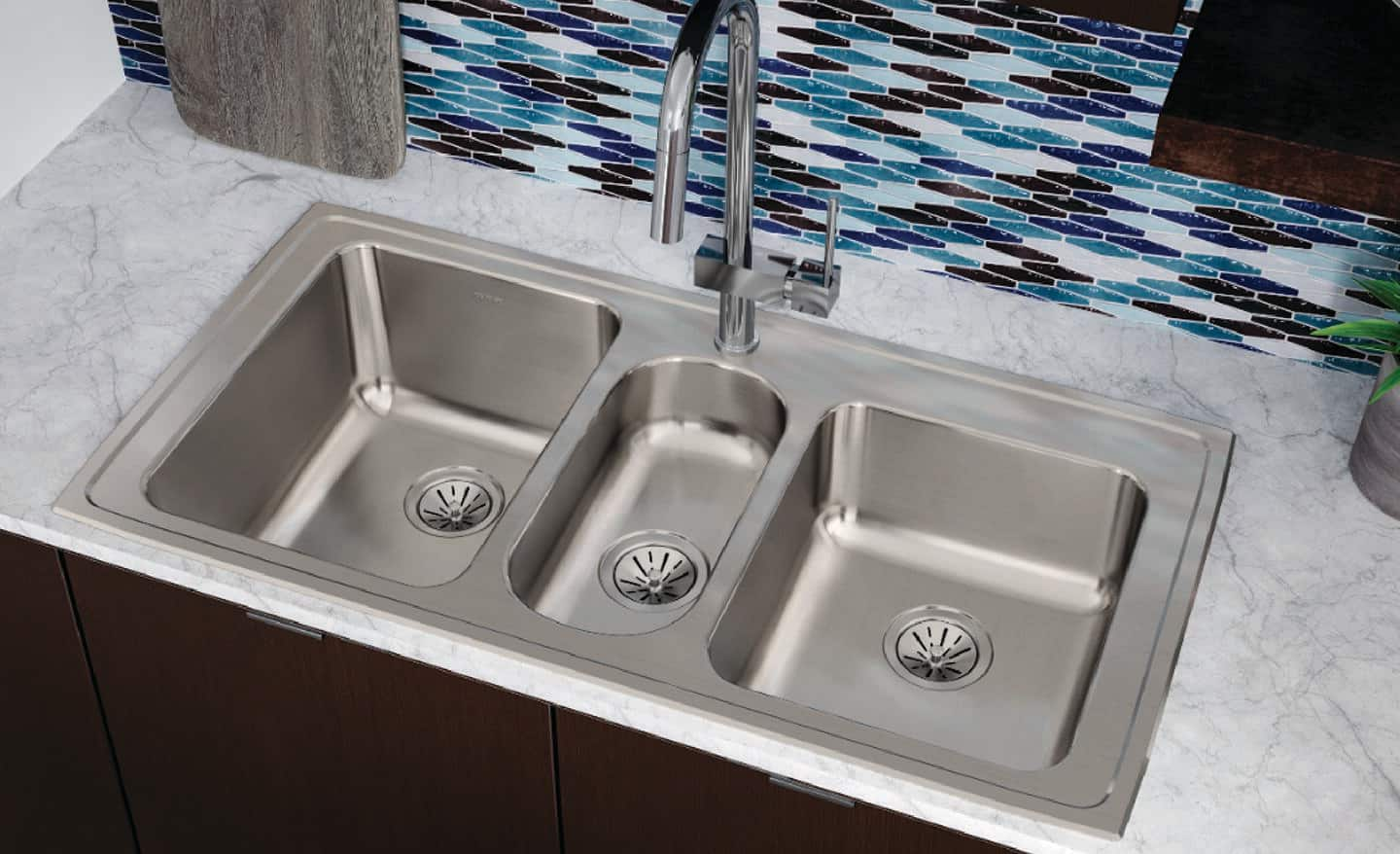 A triple-bowl sink in a kitchen.