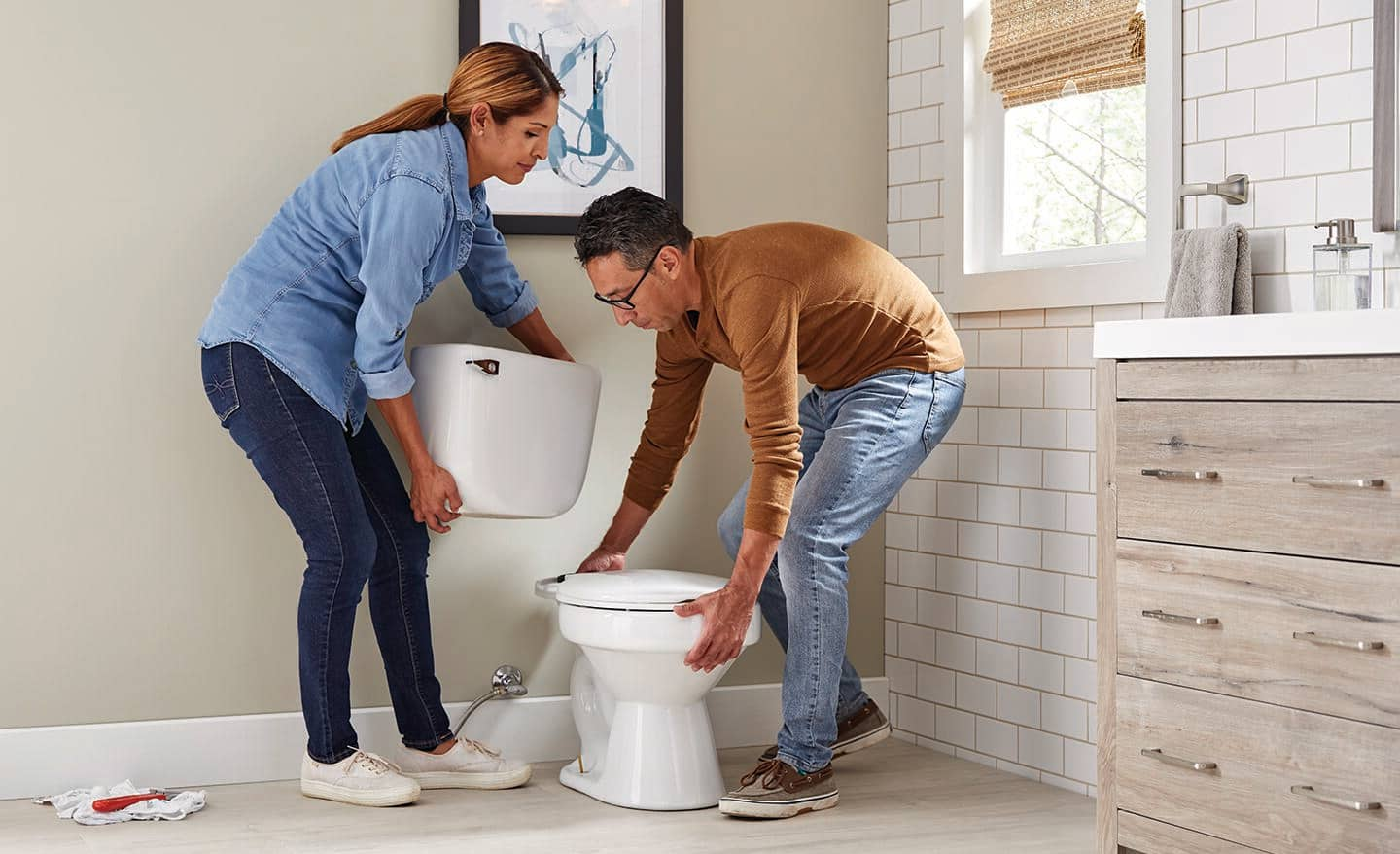 Two people installing a toilet.