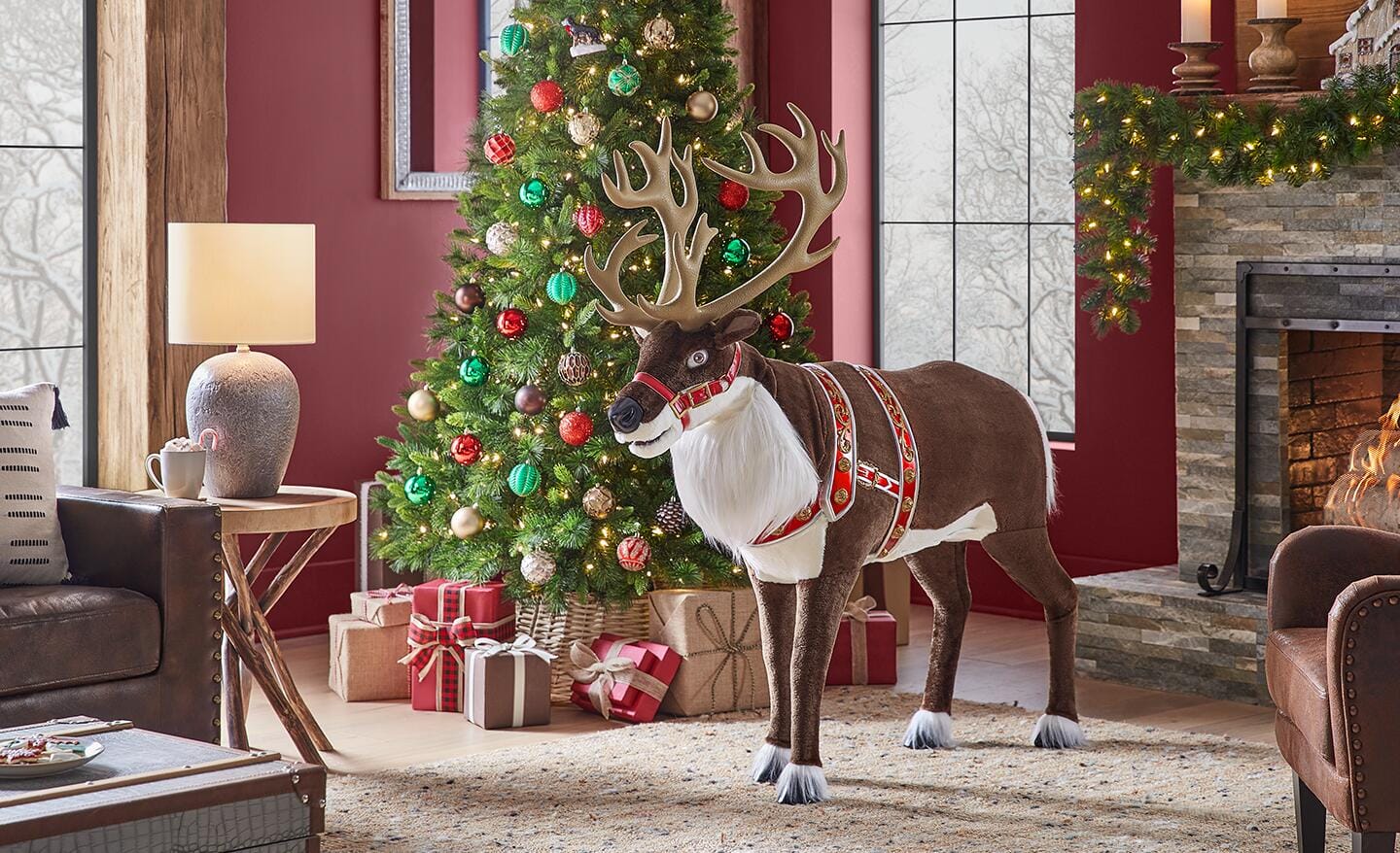 An animatronic reindeer stands near a decorated Christmas tree and brightly colored gifts. An animatronic reindeer stands near a decorated Christmas tree and brightly colored gifts.