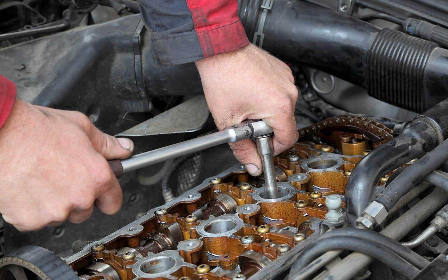A person installs new spark plugs. 