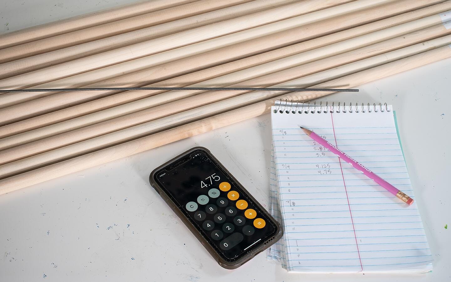 Wooden dowels placed on table with calculator and paper. Wooden dowels placed on table with calculator and paper.