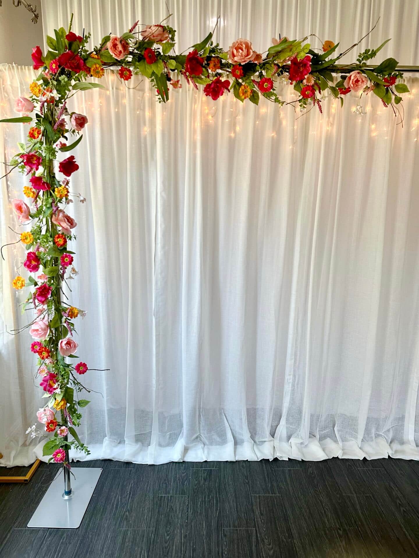 Artificial flower garlands on a backdrop stand