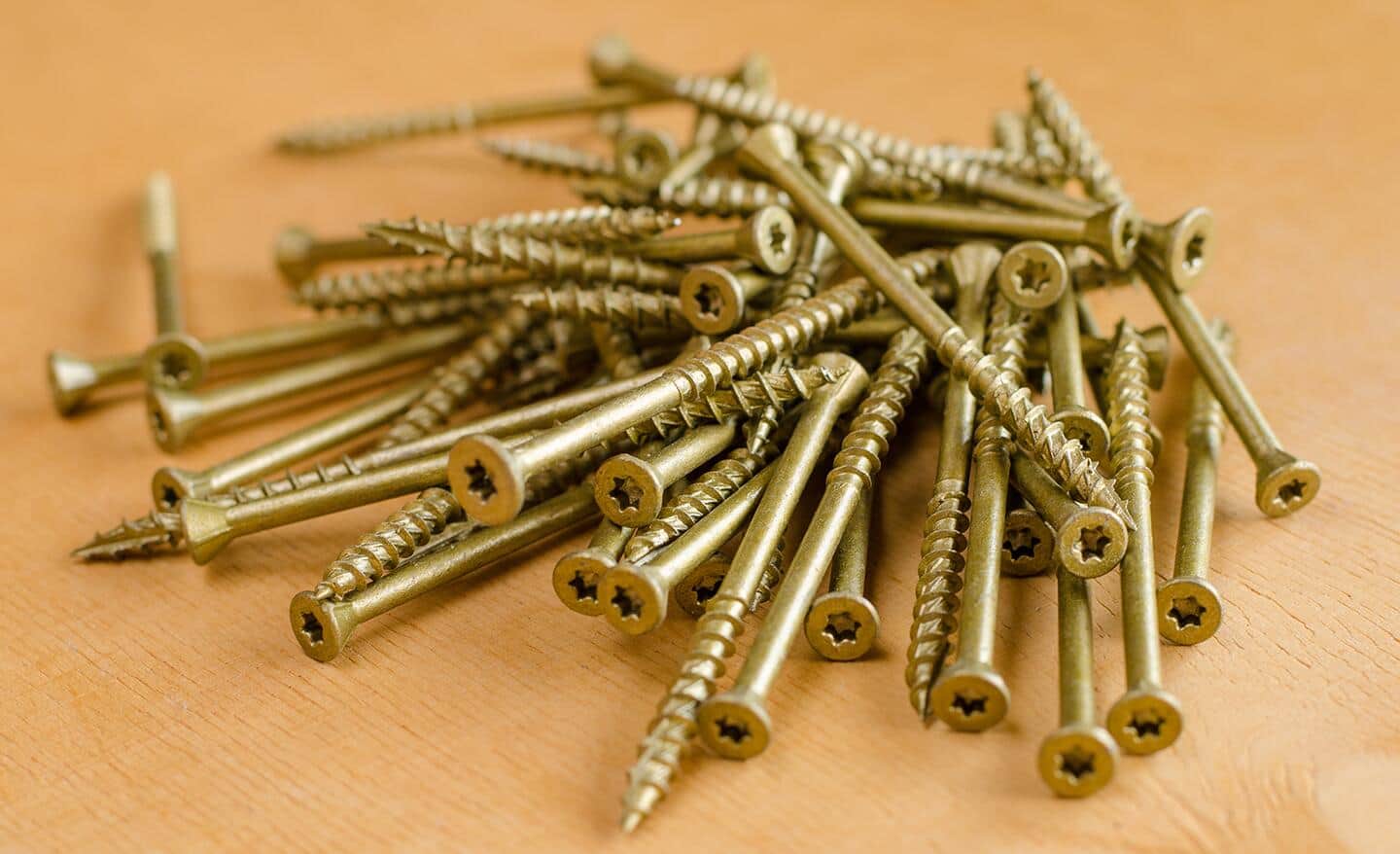 A pile of coarse drywall screws sitting on a table.