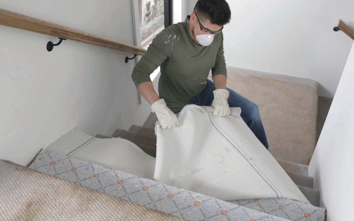 A person pulling carpeting from stairs A person pulling carpeting from stairs