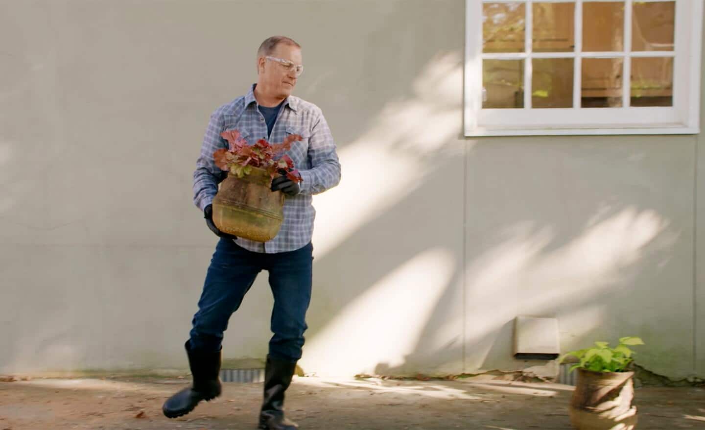 A man holding a plant.