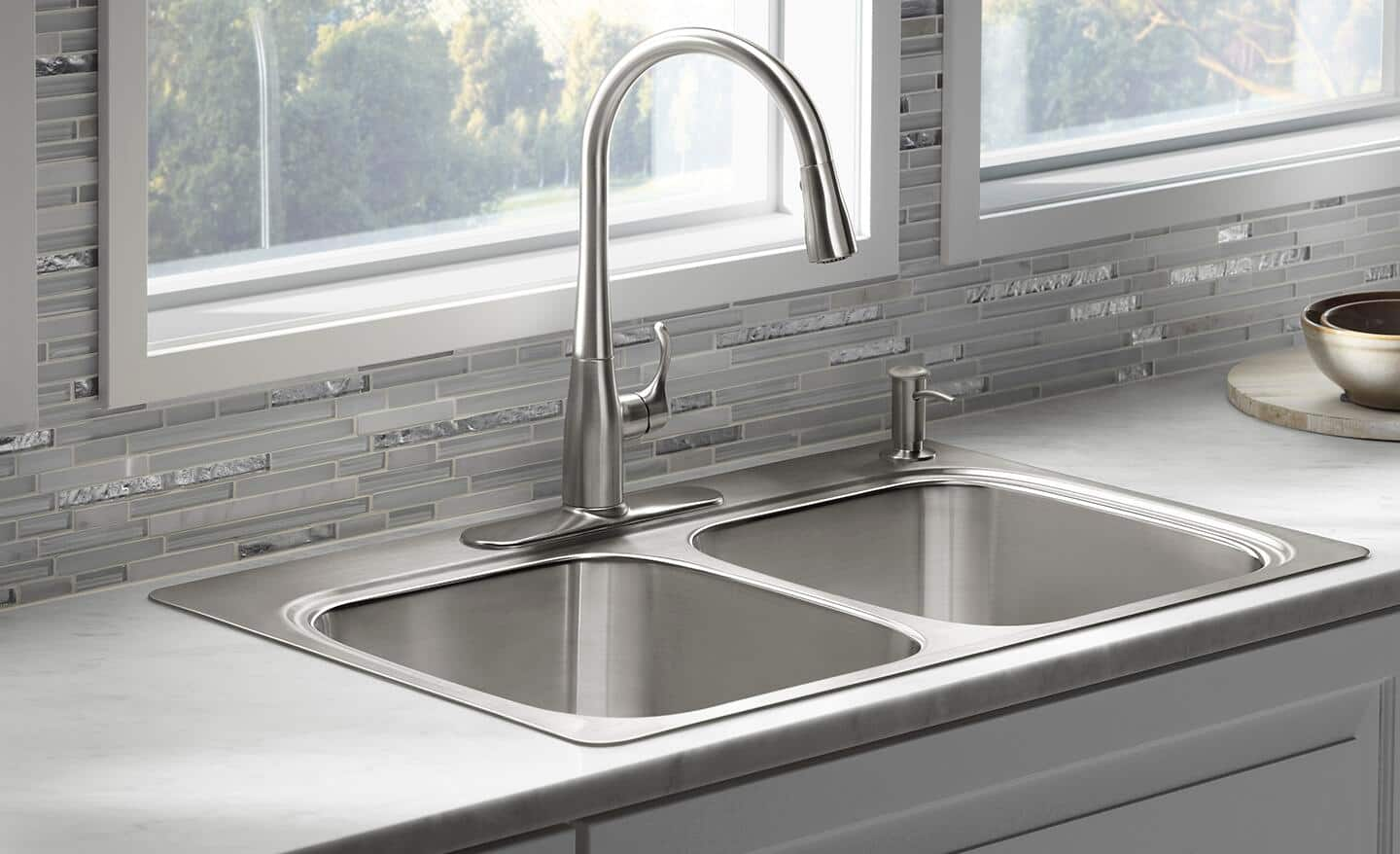 An installed drop-in, double-bowl kitchen sink.