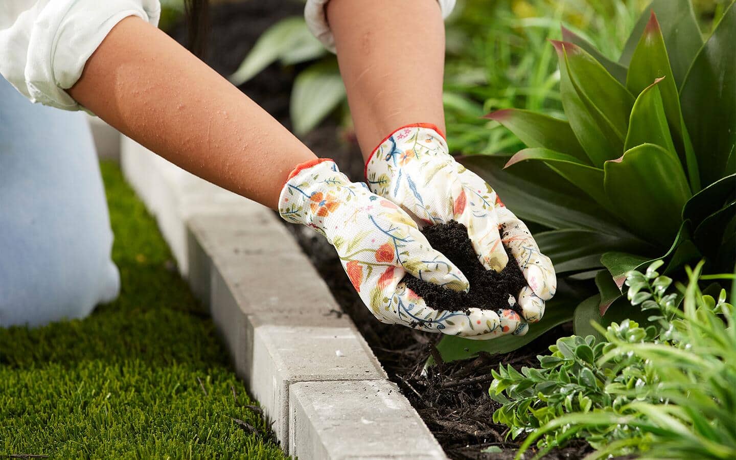 A gardener holds soil in gloved hands A gardener holds soil in gloved hands