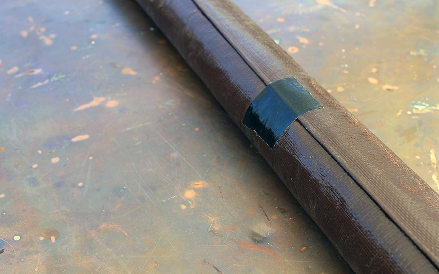 A piece of tape is used to keep the screen rolled up.