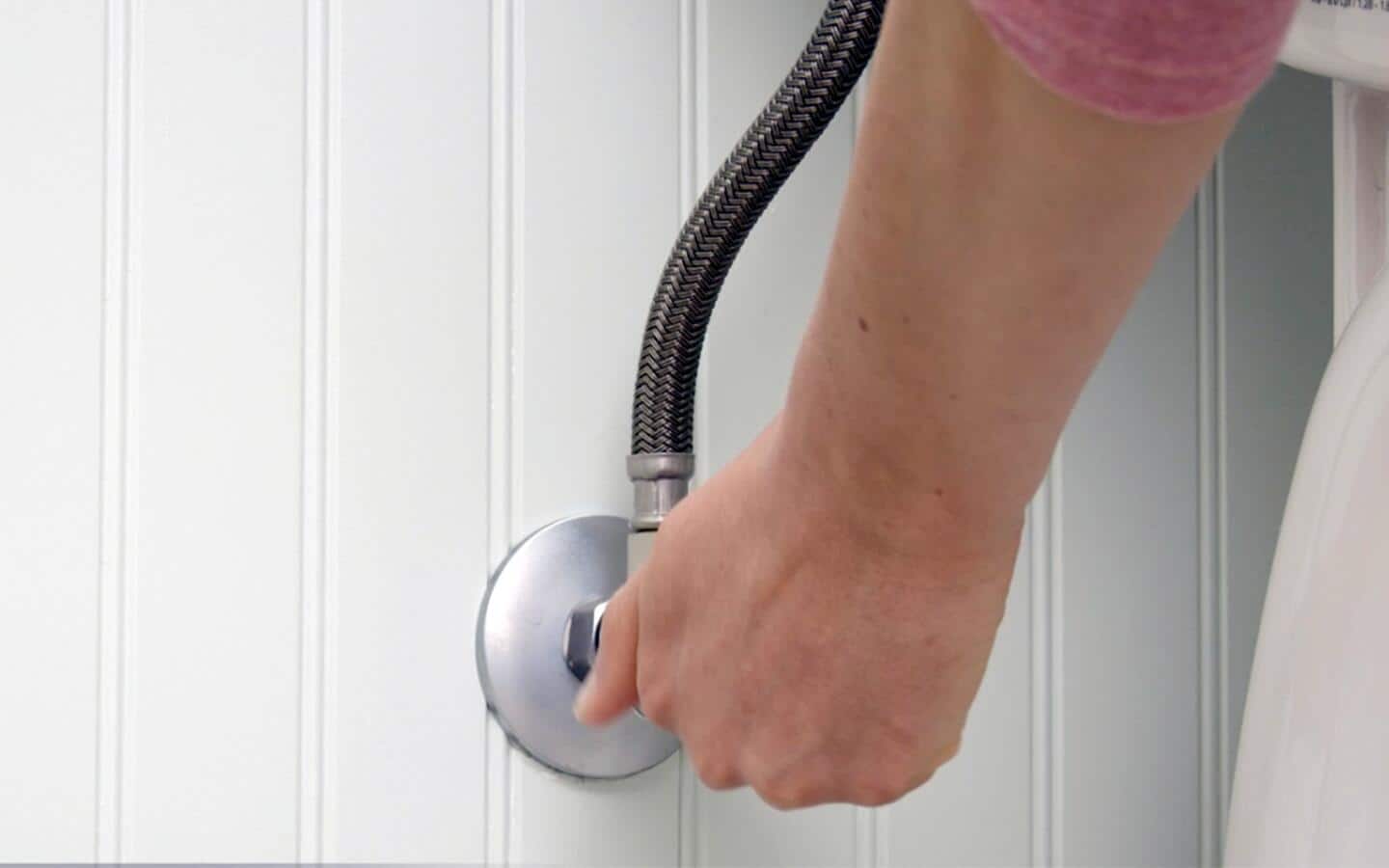 A person adjusting the water supply valve. A person adjusting the water supply valve.