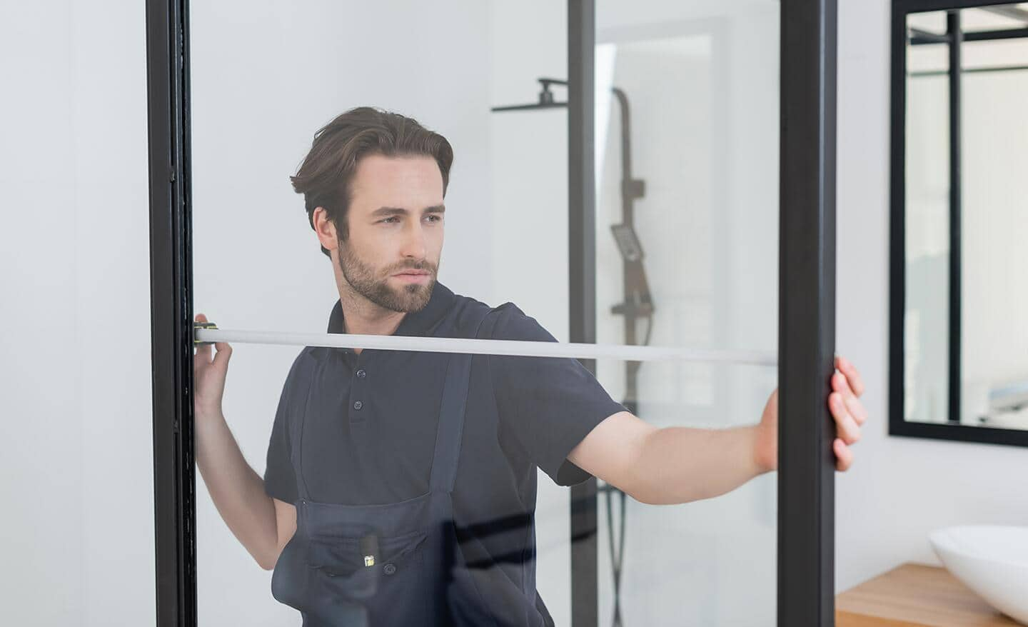 Someone measuring a shower door.