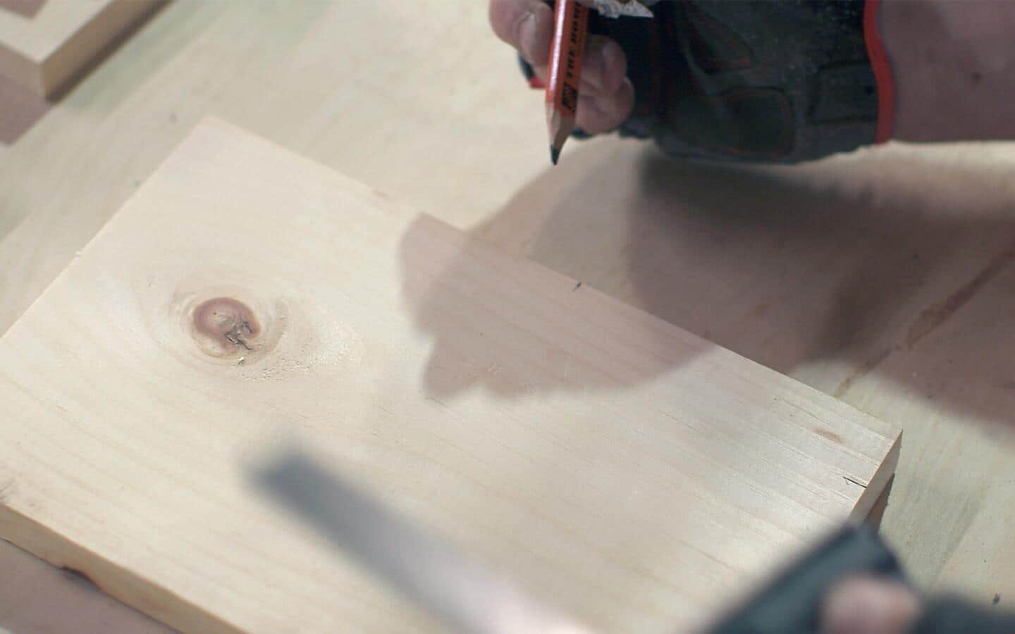 A piece of wood being measured and marked with a pencil.