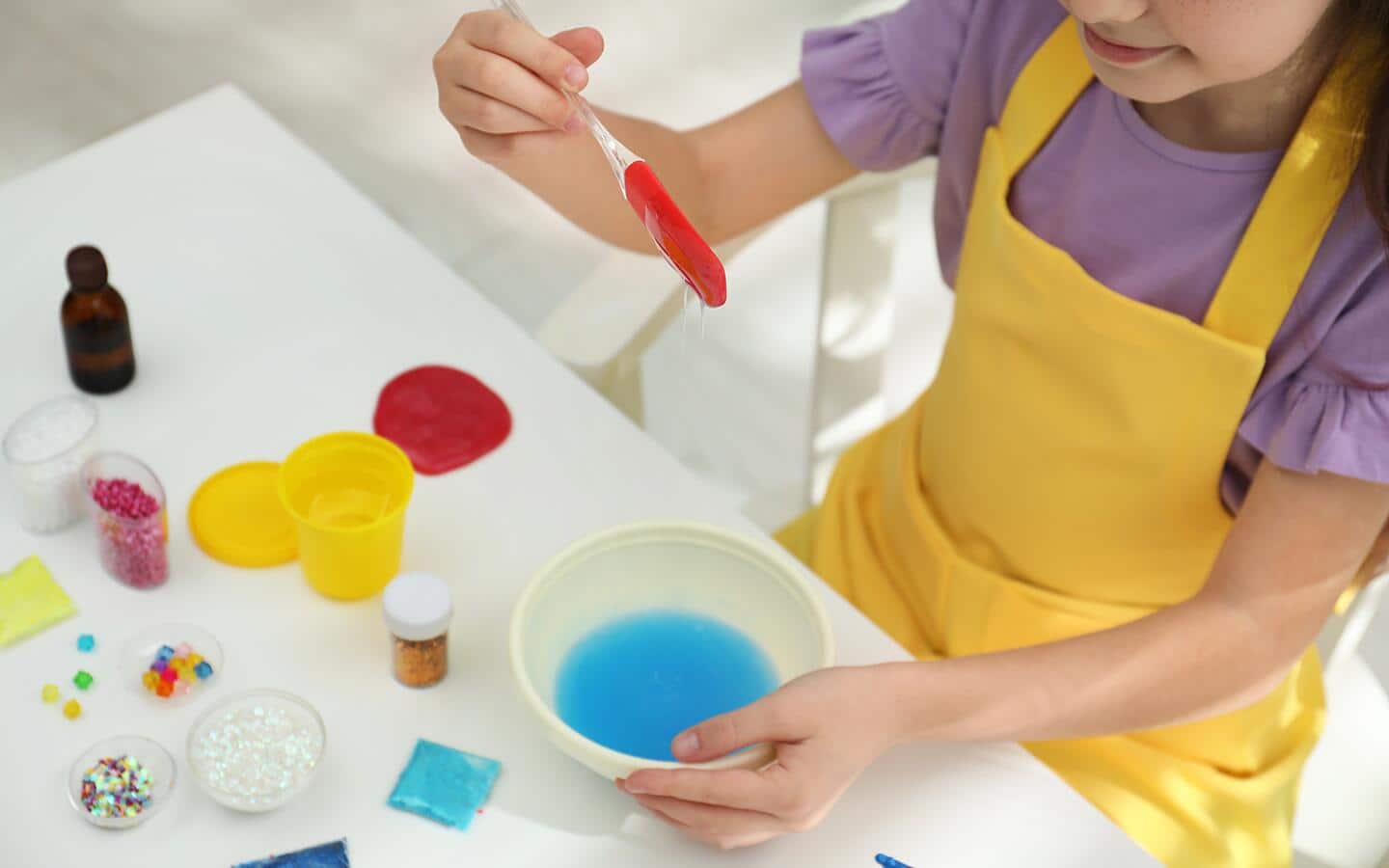 A child making glueless slime in a bowl. A child making glueless slime in a bowl.
