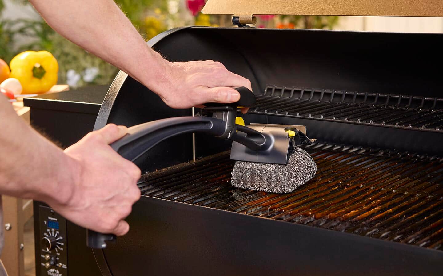 Someone scrubbing the grate of a pellet smoker. Someone scrubbing the grate of a pellet smoker.