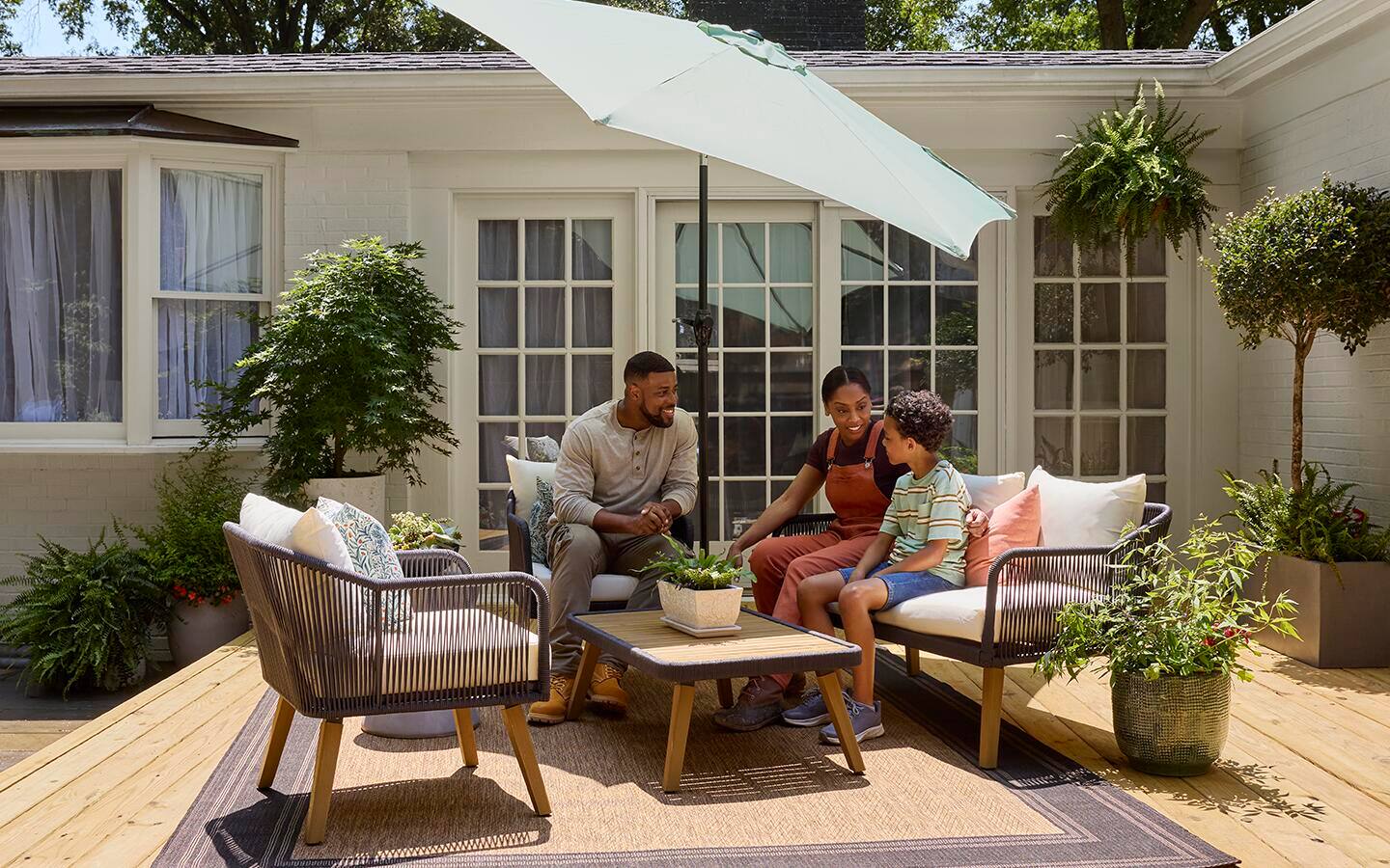 People sitting on sofas and chairs on a sunny patio in spring