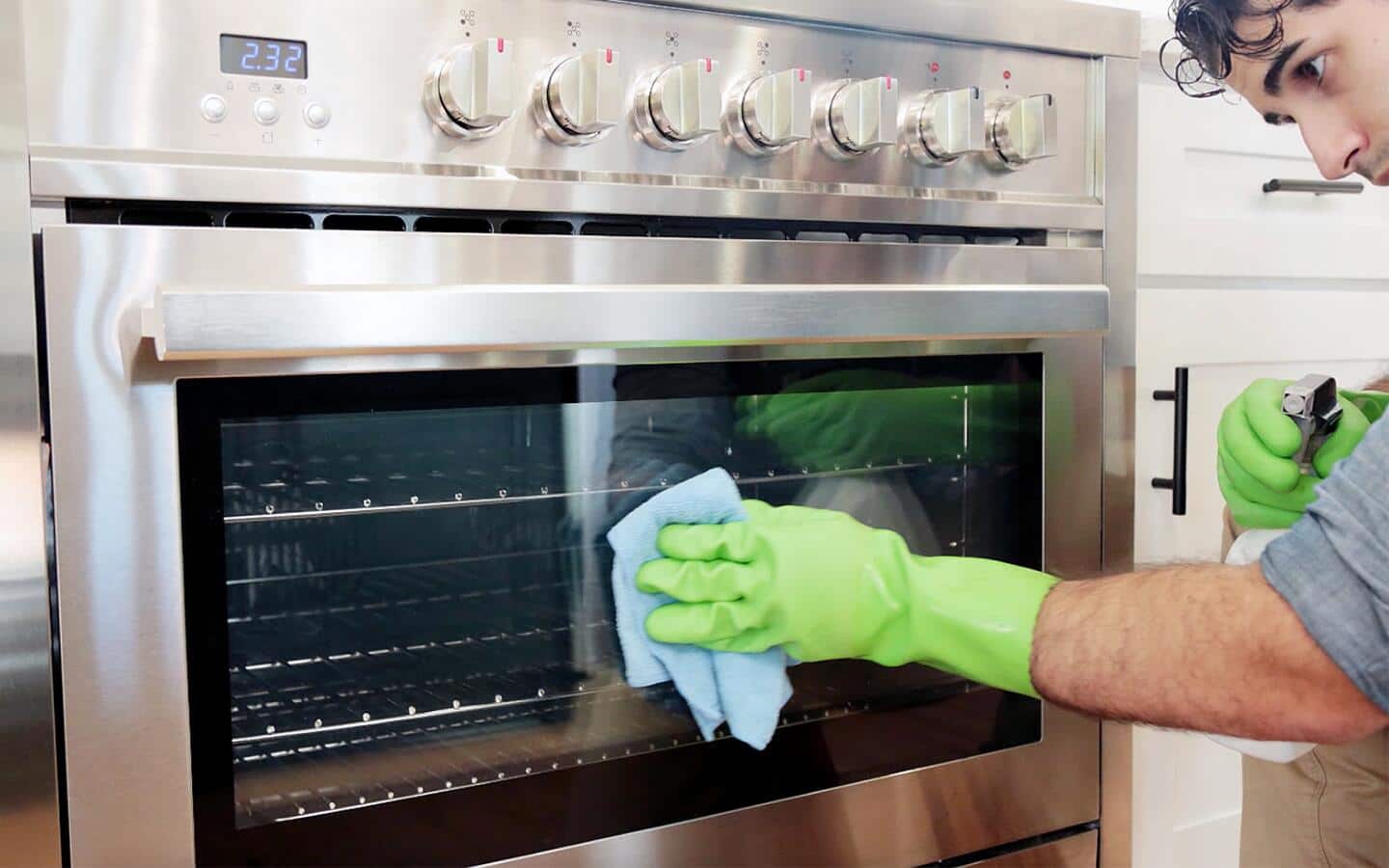 Someone cleaning an oven door. Someone cleaning an oven door.