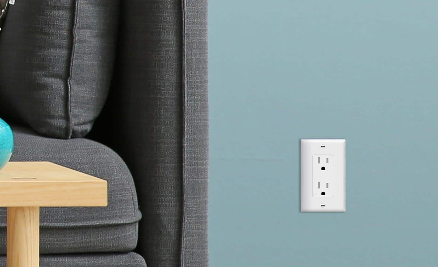 A 15-amp duplex receptacle outlet installed next to a sofa.