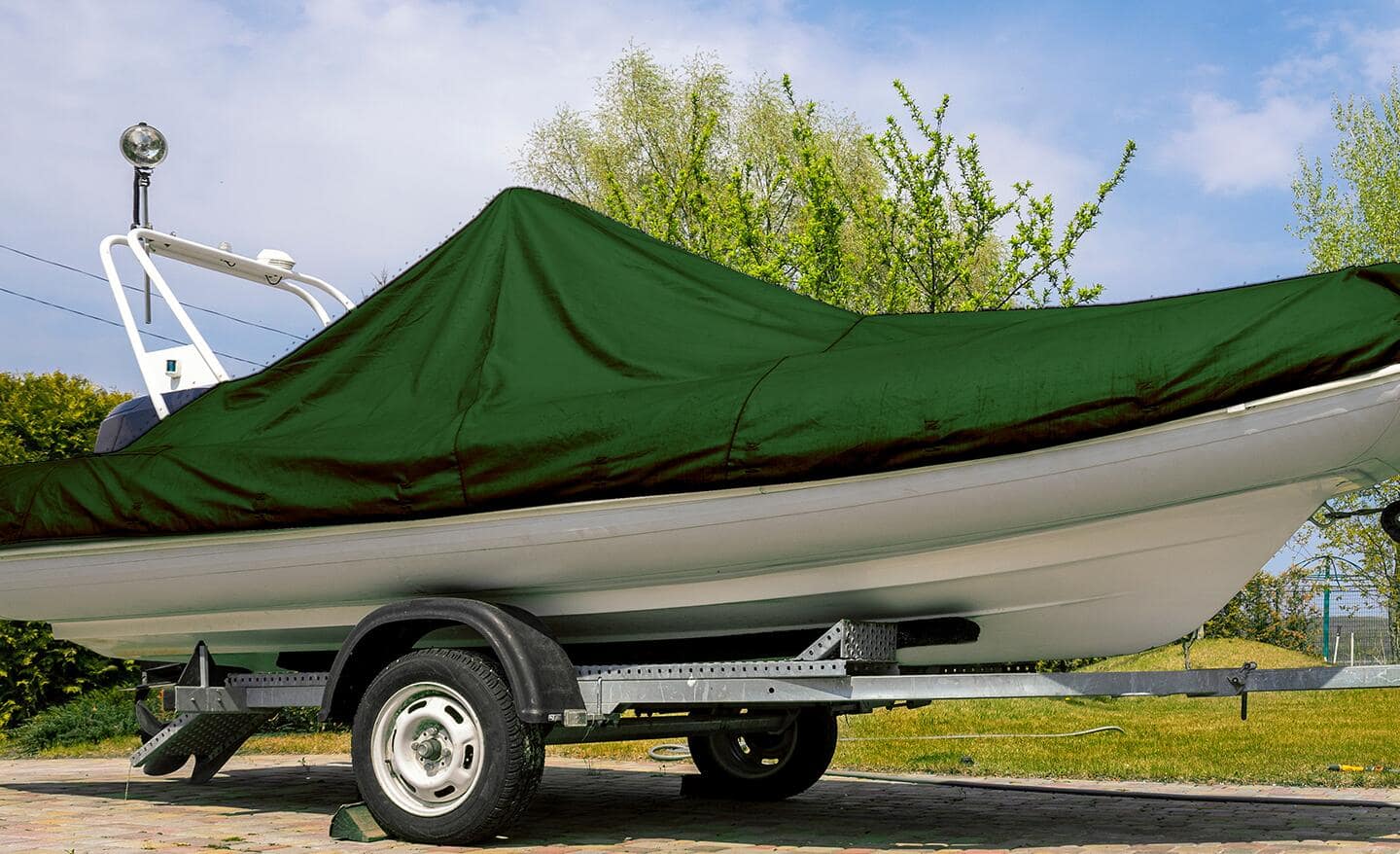 A green, UV-resistant tarp covers a small boat.