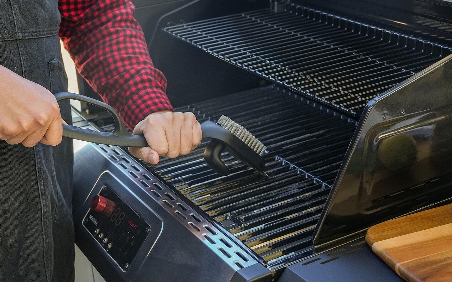 Someone wiping down a gas grill. Someone wiping down a gas grill.