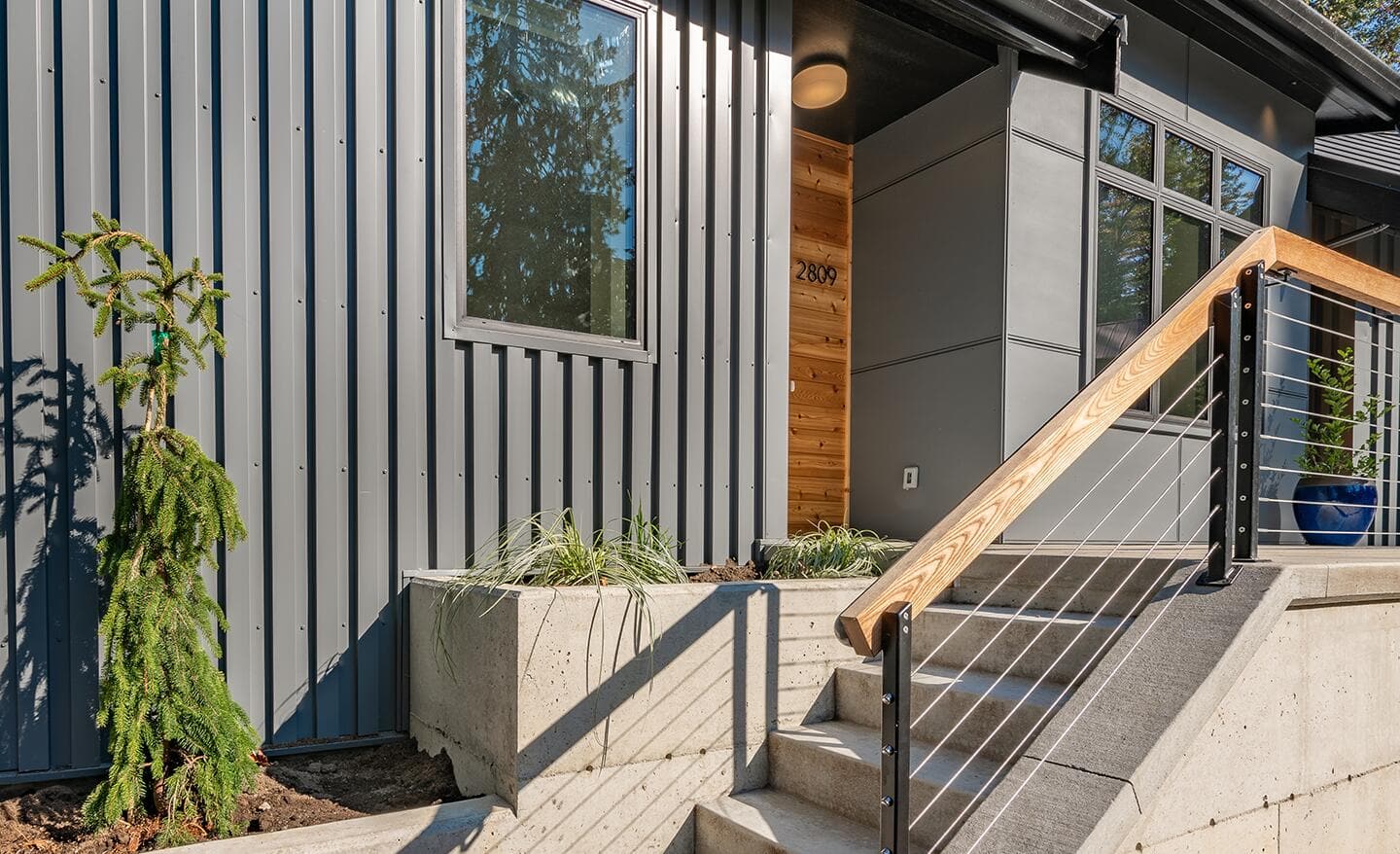 A modern home featuring vertical gray metal siding.