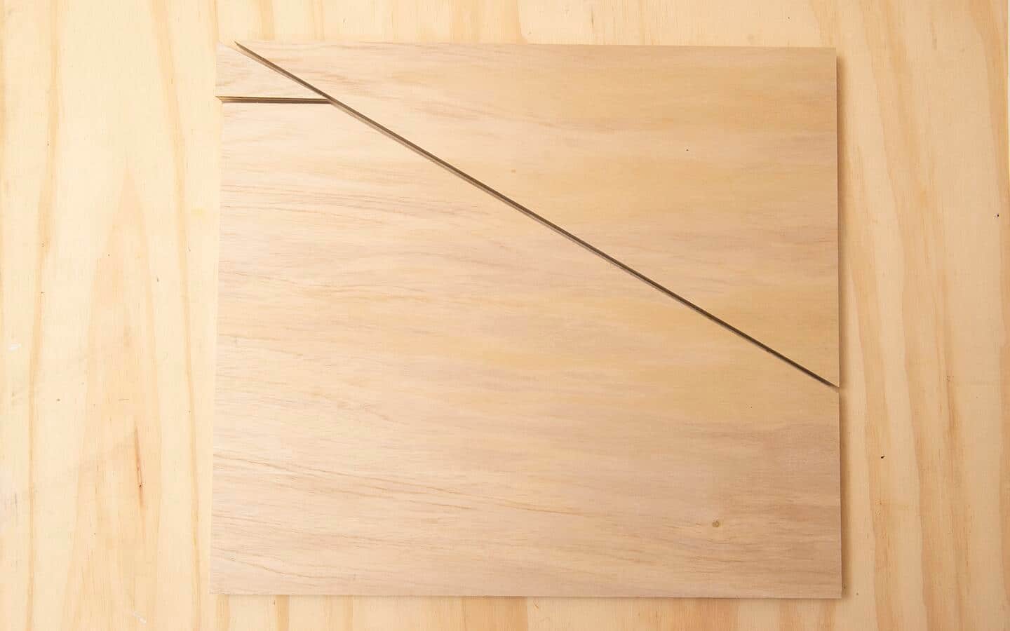 A piece of plywood, showing the angle cuts that make a support leg for a DIY soccer rebounder board. A piece of plywood, showing the angle cuts that make a support leg for a DIY soccer rebounder board.