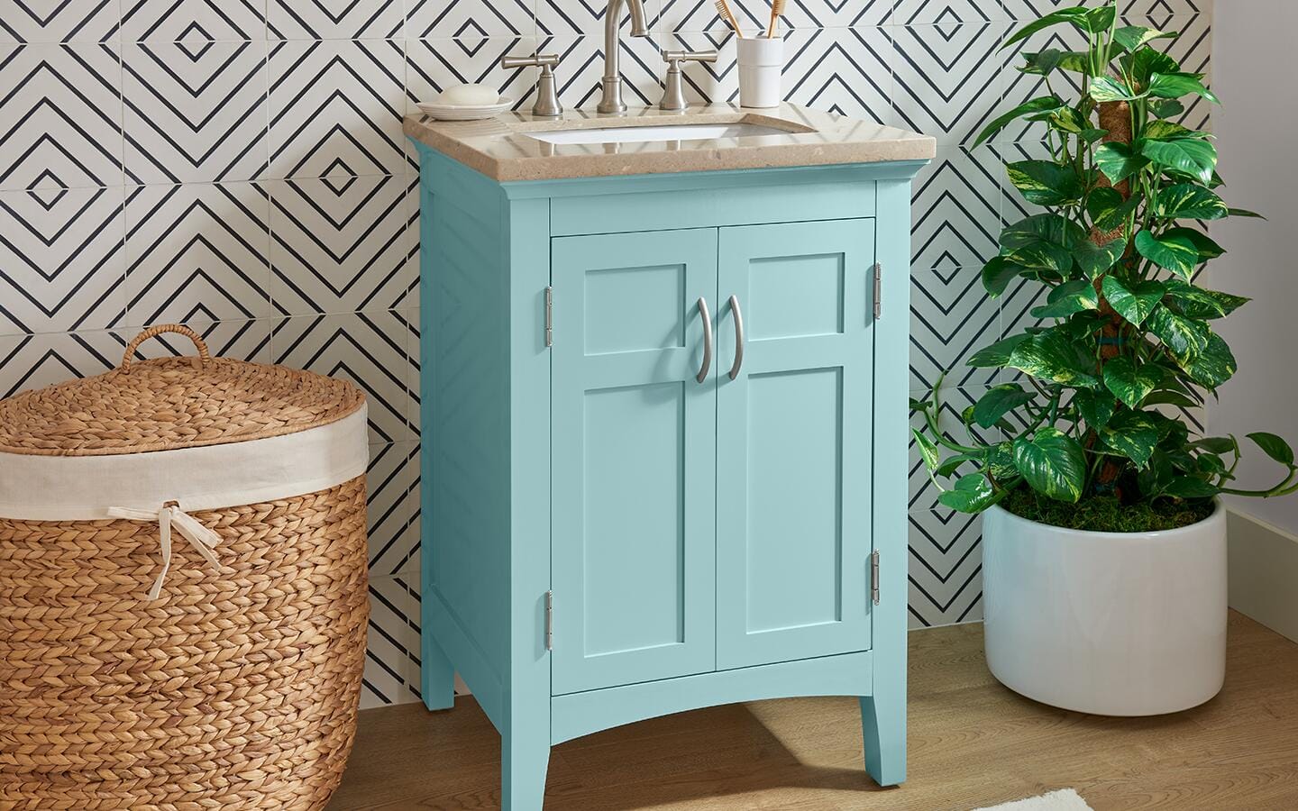 A bathroom vanity painted aqua blue in-between a wicker basket and a houseplant. A bathroom vanity painted aqua blue in-between a wicker basket and a houseplant.