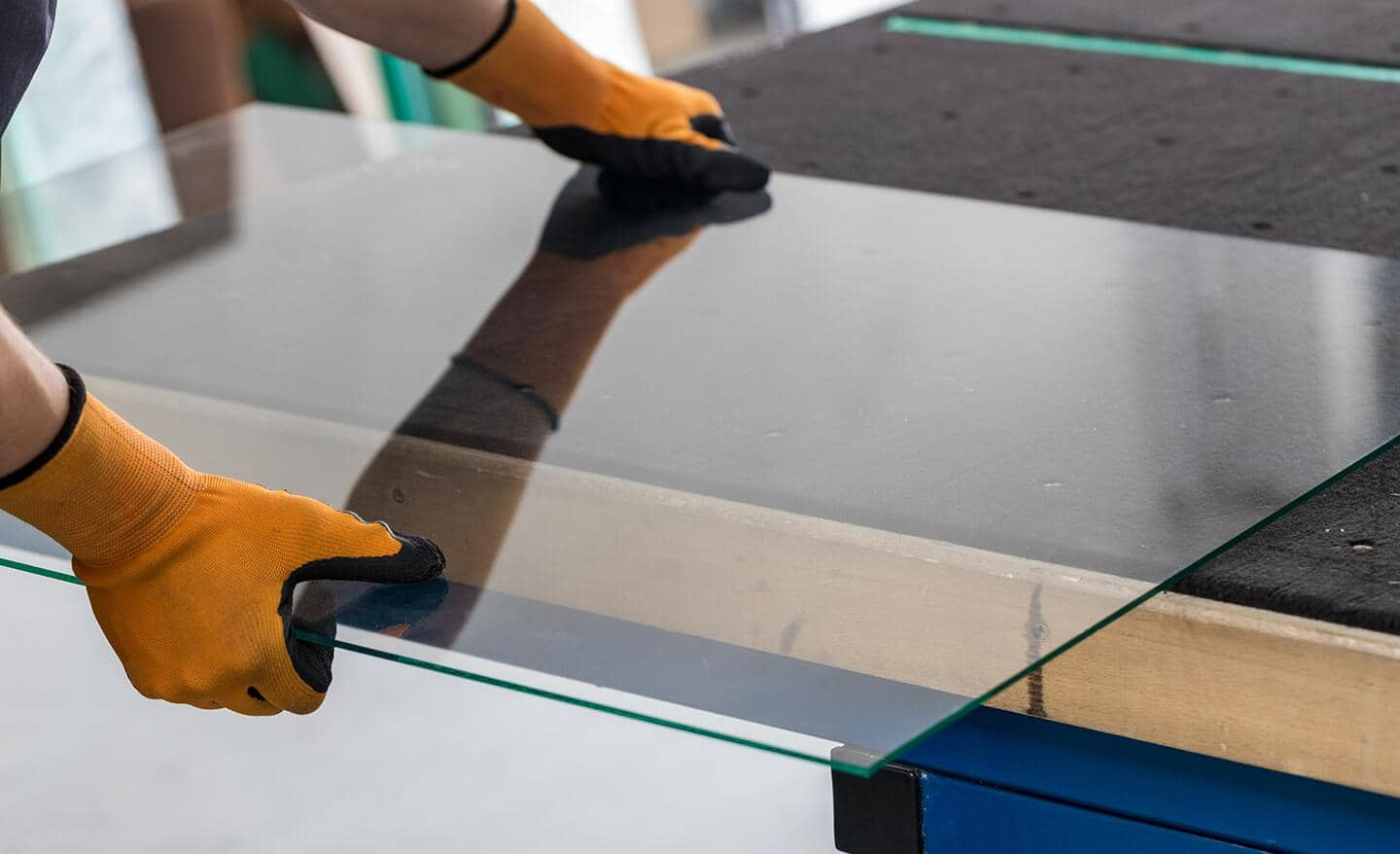 A piece of glass is positioned over the edge of a work surface.