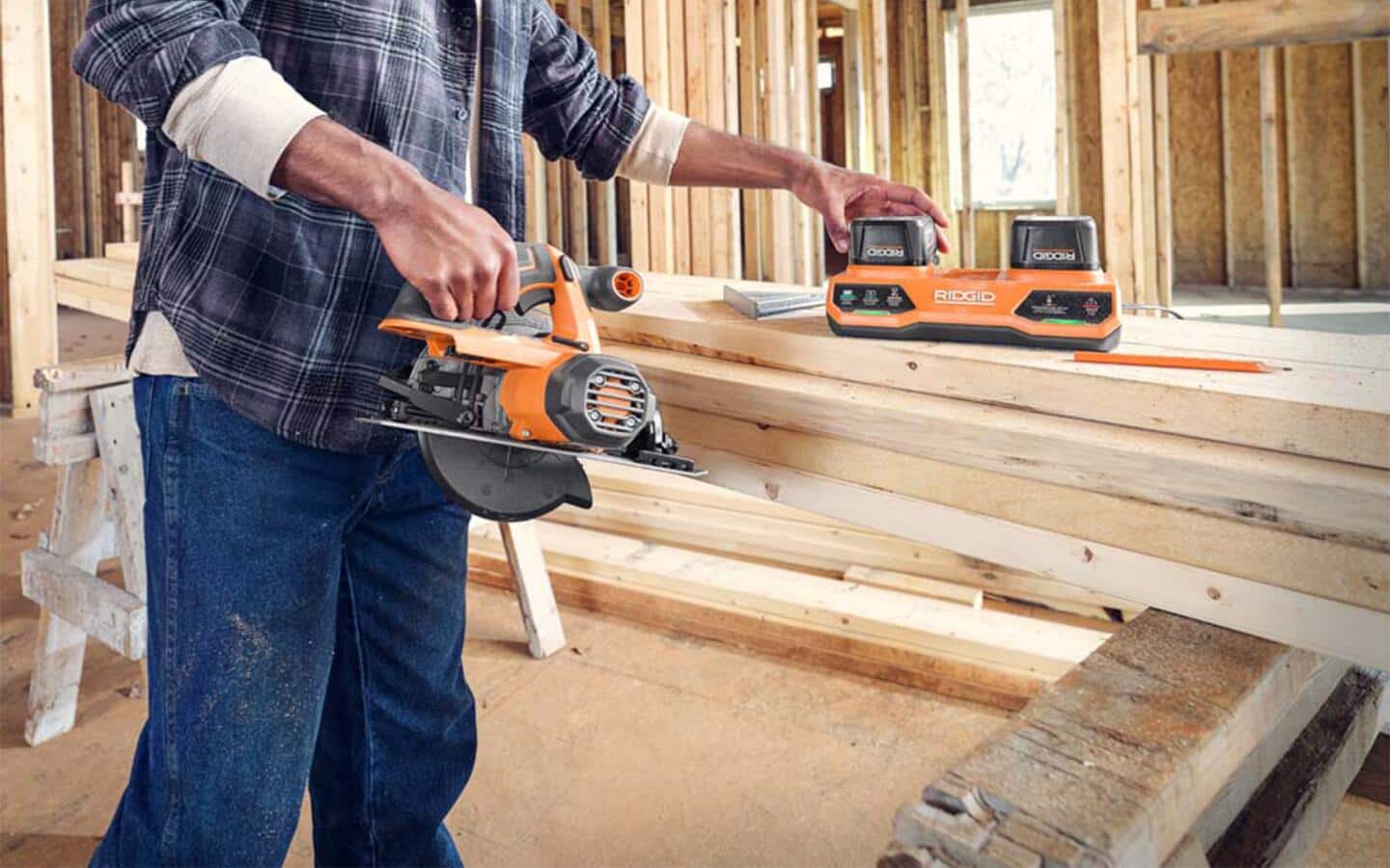 A person gathering tools and boards to frame a wall. A person gathering tools and boards to frame a wall.