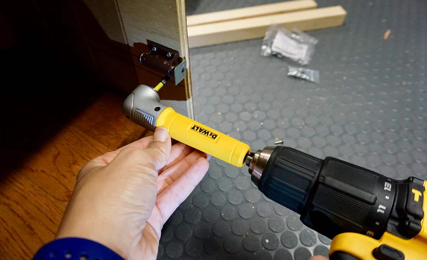 A person attaches a drill bit extender to a drill.