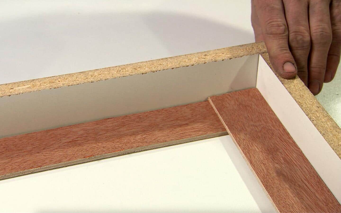 A person joins two corners of a concrete form. A person joins two corners of a concrete form.