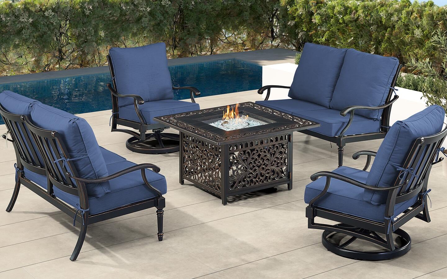 A patio with furniture and a square fire pit.