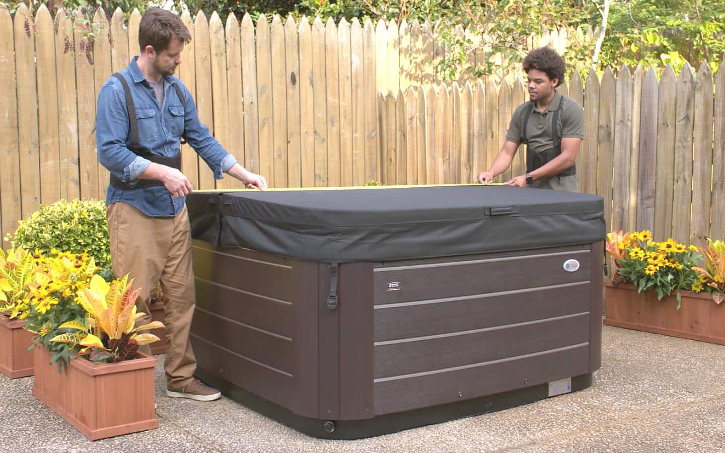 Two men measuring the width of a covered hot tub.