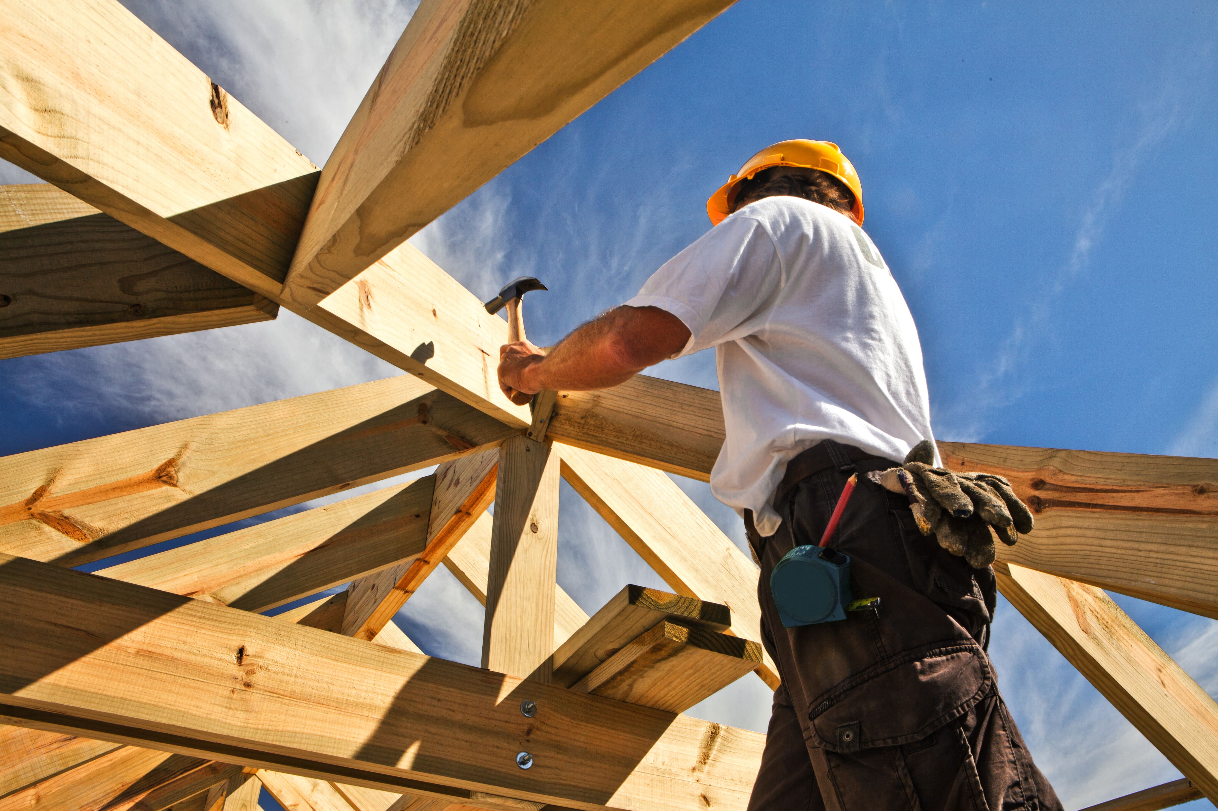 A carpenter frames a roof.