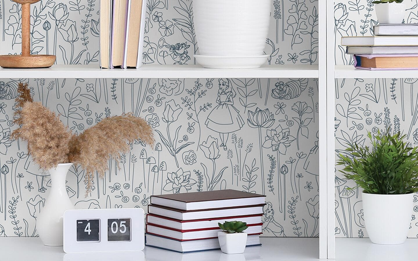 The back interior of a white bookshelf is decorated with a storybook-inspired peel and stick wallpaper. The back interior of a white bookshelf is decorated with a storybook-inspired peel and stick wallpaper.