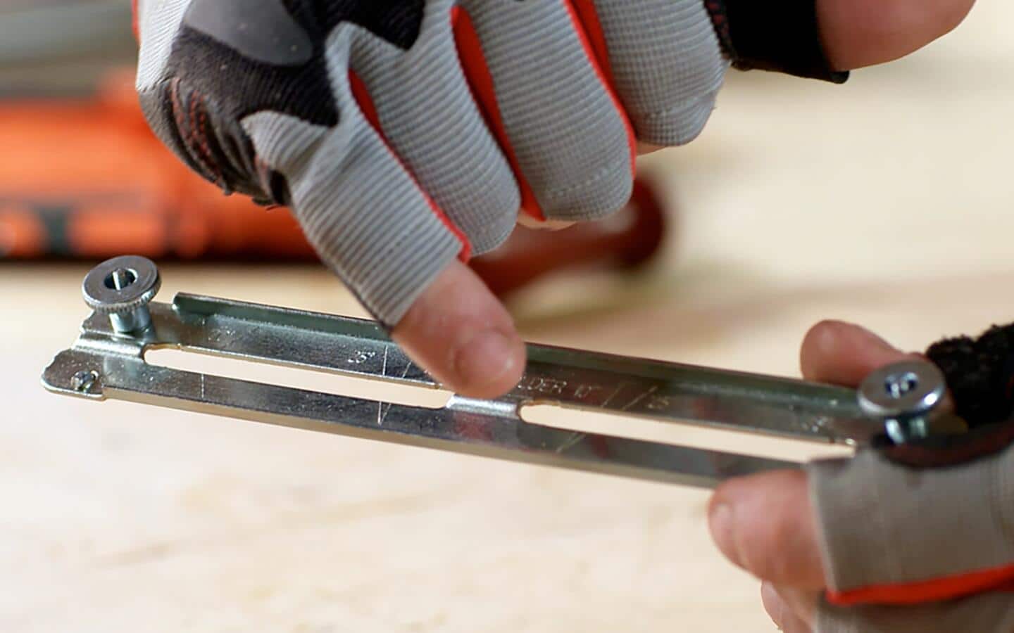 A person points out the angle lines on a guide for a chainsaw. A person points out the angle lines on a guide for a chainsaw.