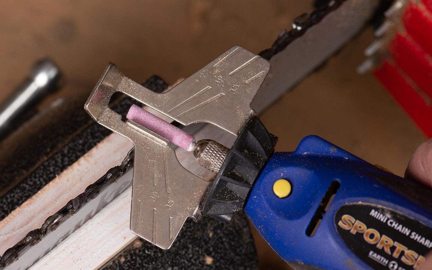 An electric sharpening tool is used to sharpen a chainsaw. An electric sharpening tool is used to sharpen a chainsaw.