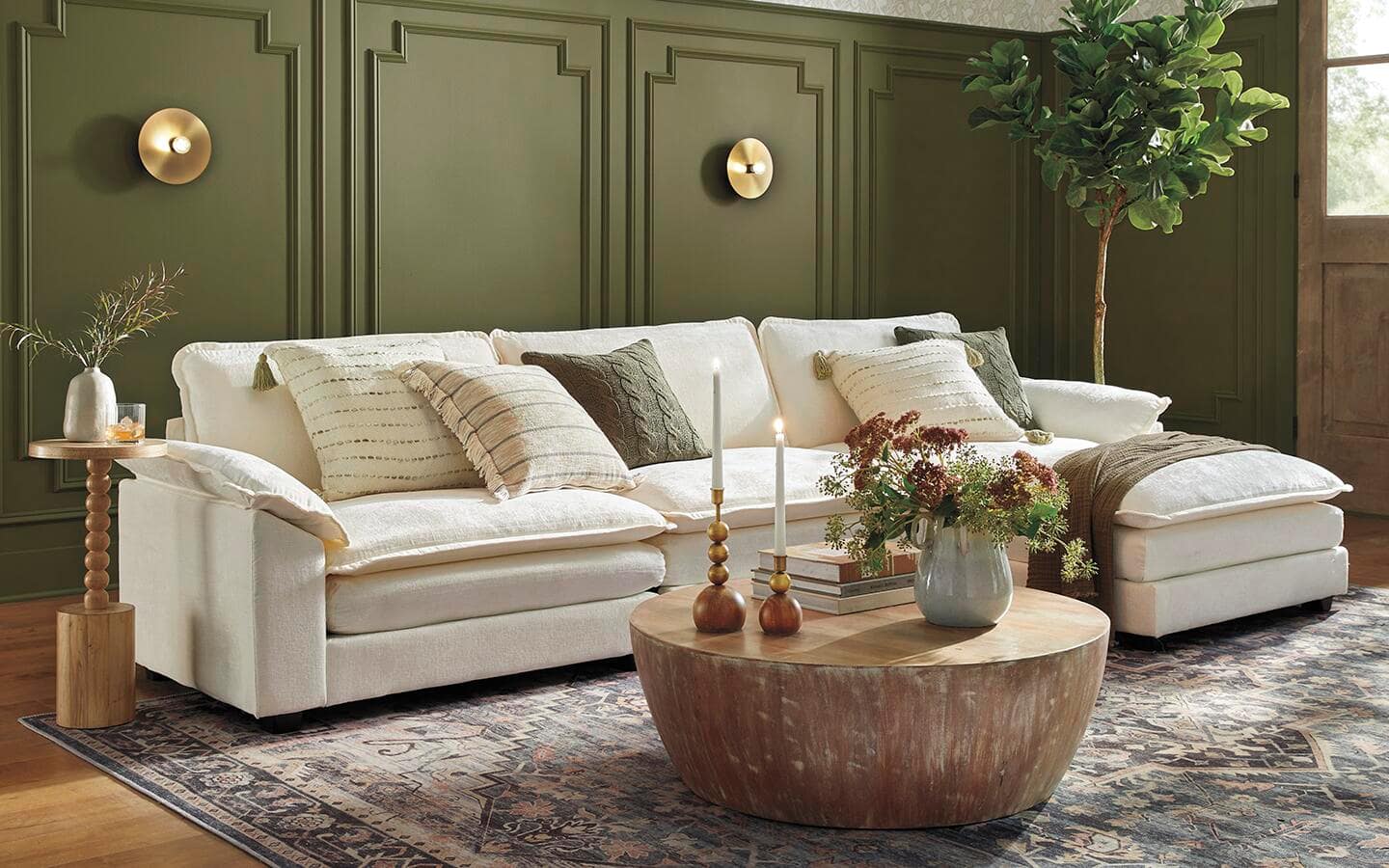 A white chaise lounge sofa placed against a green, paneled wall. A white chaise lounge sofa placed against a green, paneled wall.