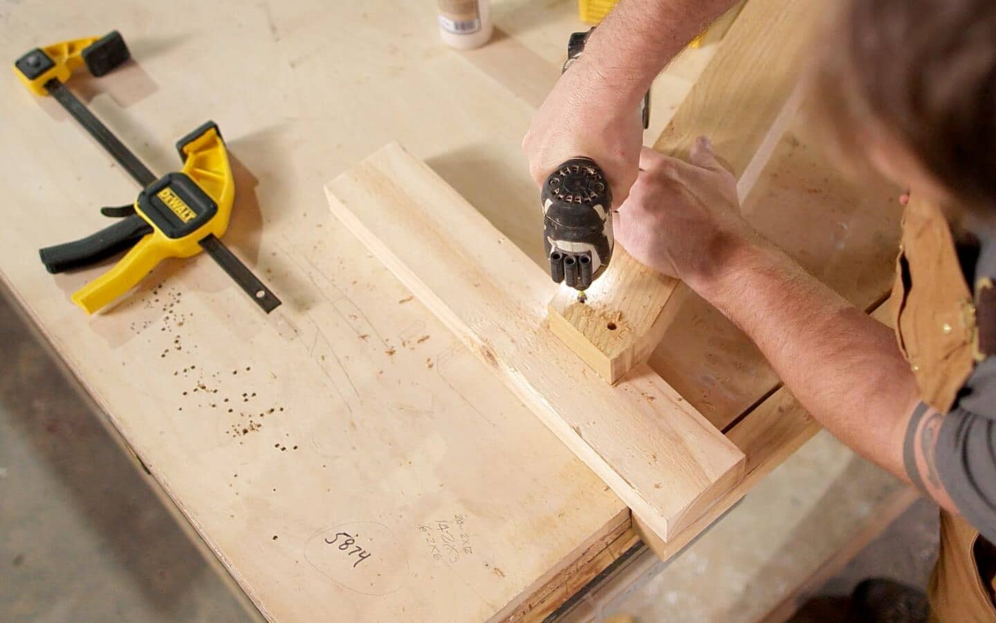 A person attaching more pieces with a drill. A person attaching more pieces with a drill.