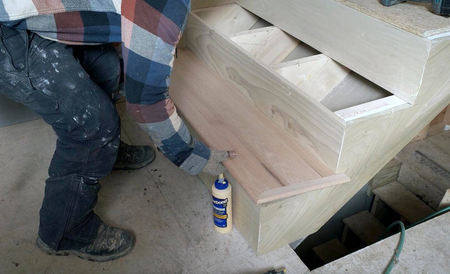 A stair tread is put into place by a construction worker.