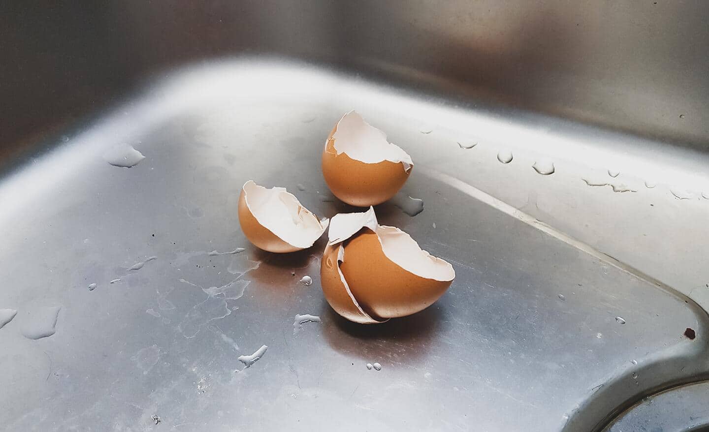Broken egg shells laying in a sink.