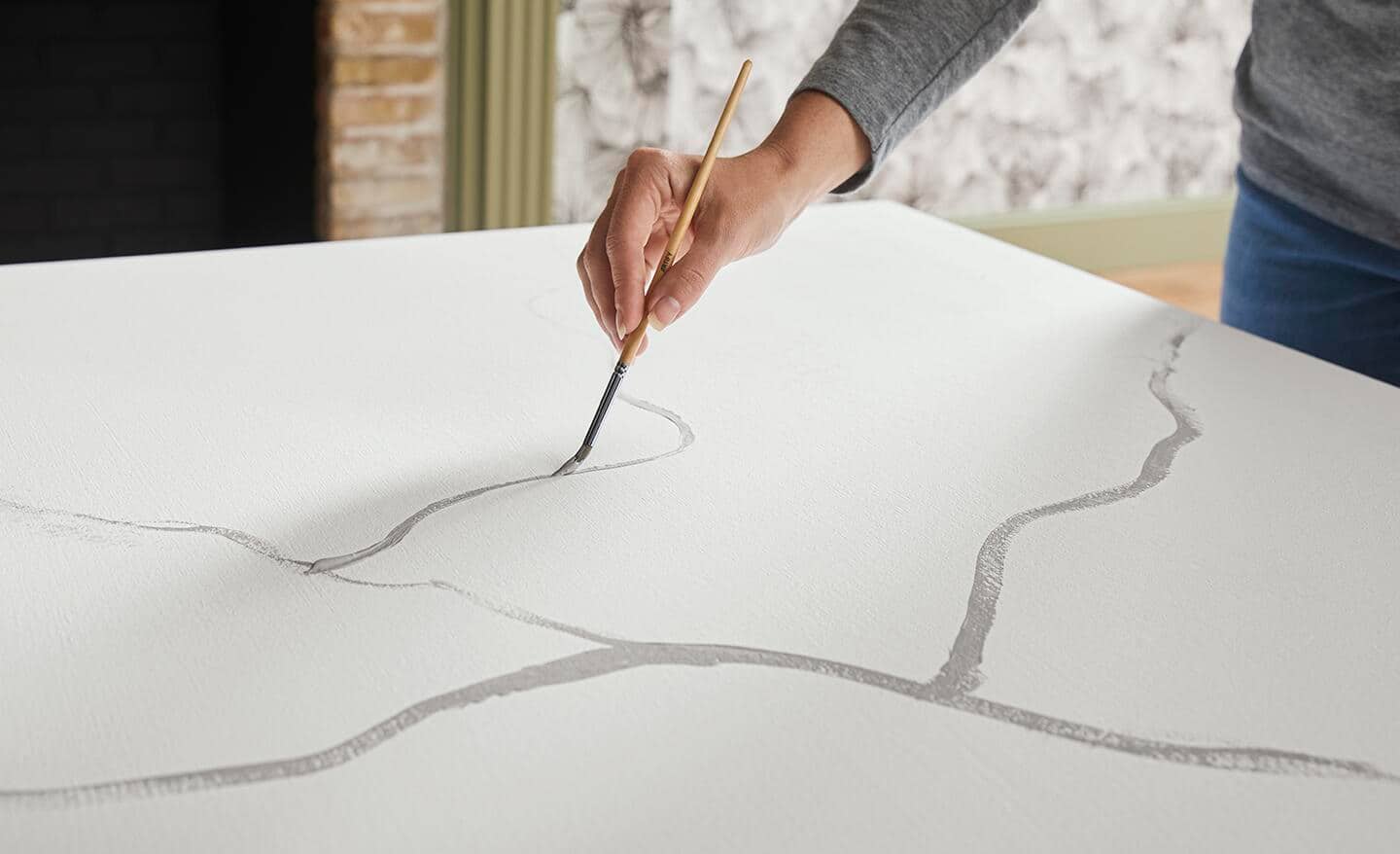 A person paints marbled veins onto a tabletop. A person paints marbled veins onto a tabletop.